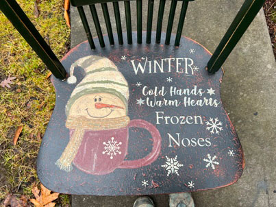 old wooden chair painted black with snowman in a mug and the saying cold hands warm hearts frozen noses