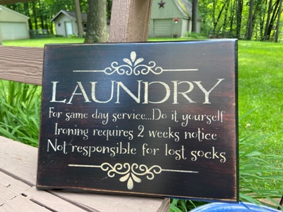 Black, wooden laundry room sign.