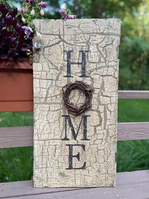Stenciled and distressed sign that says Home