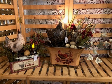 Windmill planter with rooster and eggs and a large tin that says farm fresh with a chicken in it.